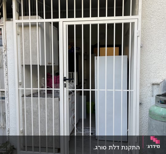 שער מתכת לבן עם סורגים בכניסה לחדר